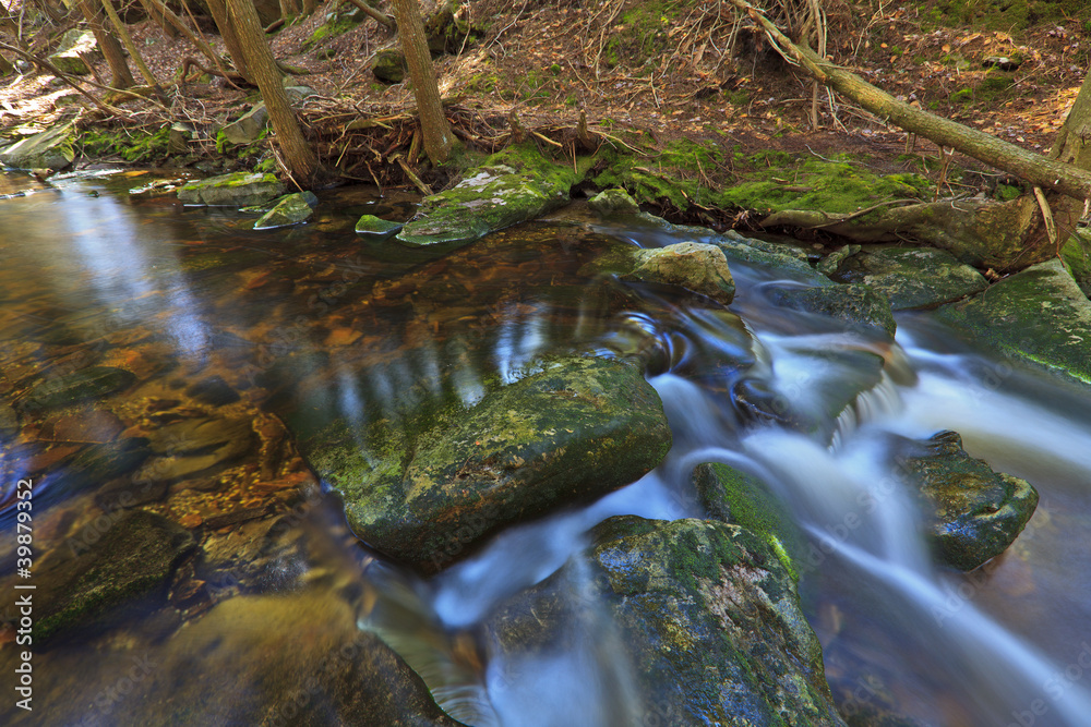 Tannin colored mountain stream and rocks in spring Tannin colored mountain stream and rocks in spring