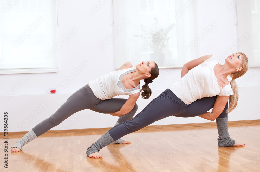 Naklejka premium Women doing yoga exercise at gym