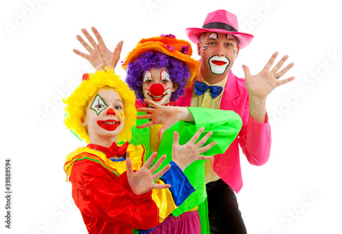 Three people dressed up as colorful funny clowns