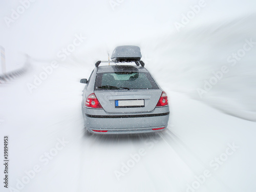 Car traveling on mountain road in snowstorm