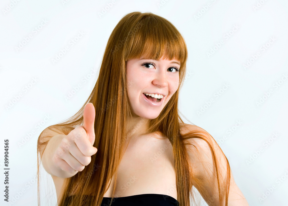 Beautiful young red-haired woman with long hair. Shows the thumb