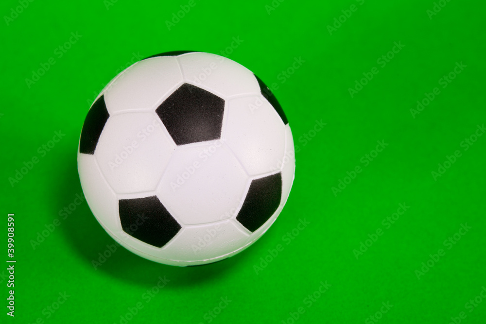 Small soccer ball over green background