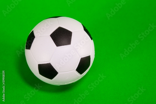 Small soccer ball over green background