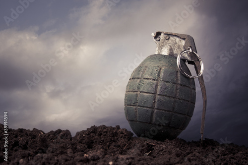 green grenade on a battlefield at dusk photo