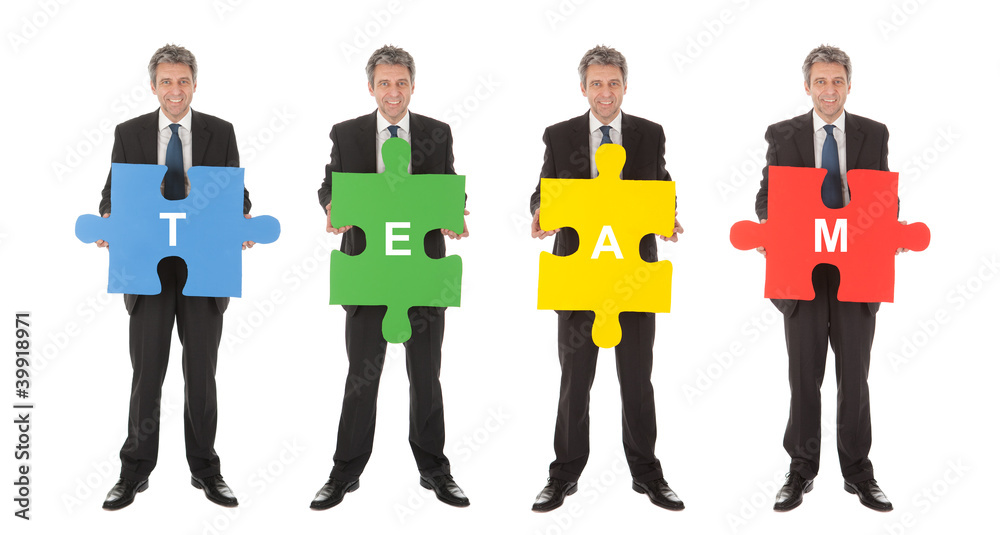 Fototapeta premium Group of business people holding jigsaw puzzle