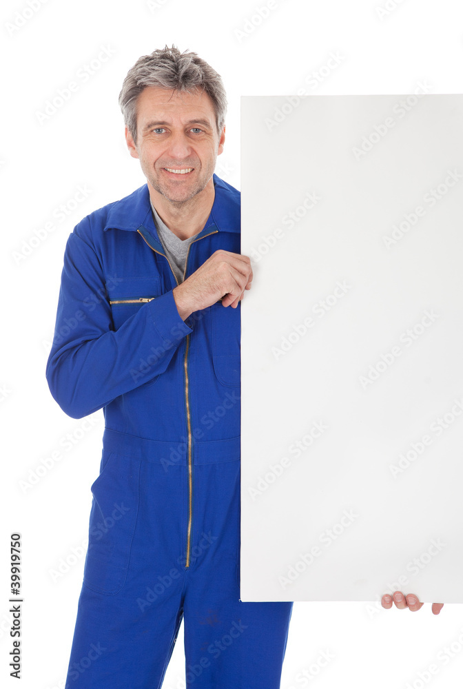 Portrait of automechanic holding empty banner