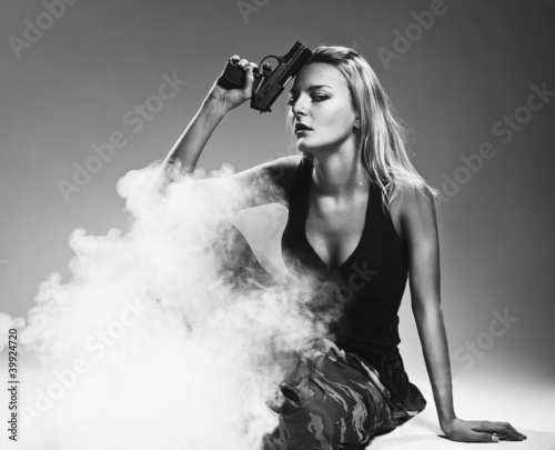 Sexy woman holding gun with smoke