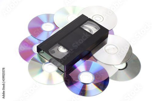 CD vs VHS. VHS cassette lay on the many CD disks isolated on whi