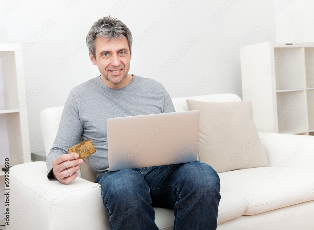 Senior man shopping at home using laptop Senior man shopping at home using laptop