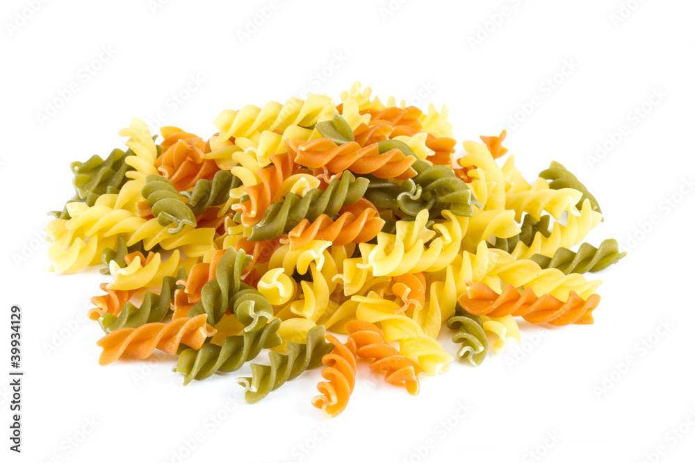 Uncooked pasta fusilli in different colours, white background Uncooked pasta fusilli in different colours, white background