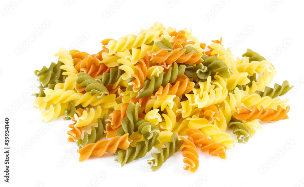 Uncooked pasta fusilli in different colours, white background Uncooked pasta fusilli in different colours, white background