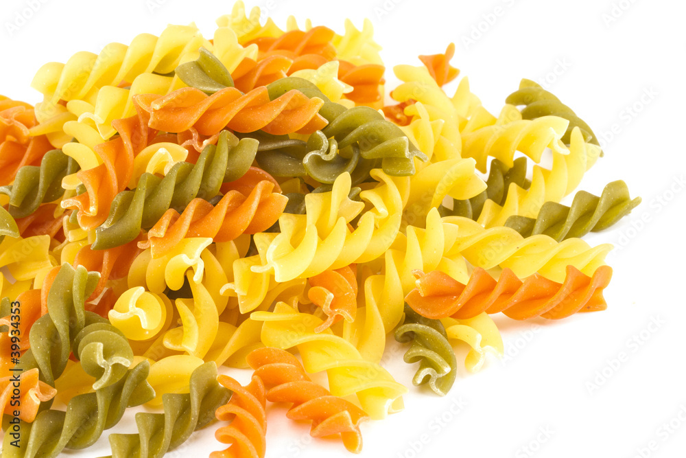 Uncooked pasta fusilli in different colours, white background Uncooked pasta fusilli in different colours, white background