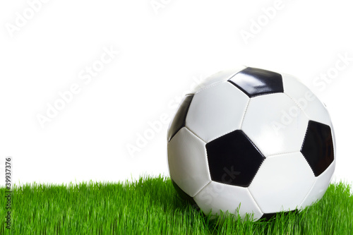 Soccer ball on grass over white background