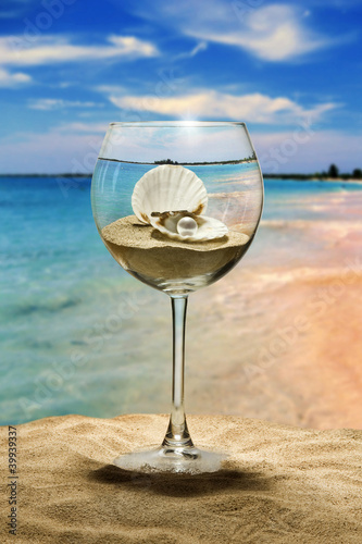 wine glass on the beach, inside the seashell with a pearl.