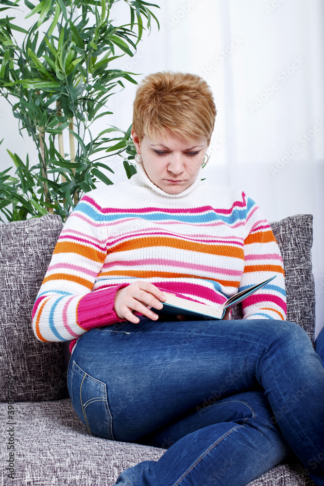 Laughing young lady sitting on sofa Laughing young lady sitting on sofa