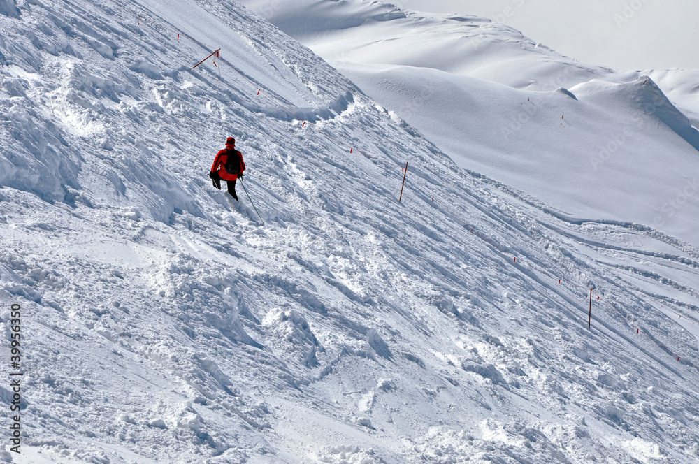 Skier going down the mountain on a slope in a sunny day