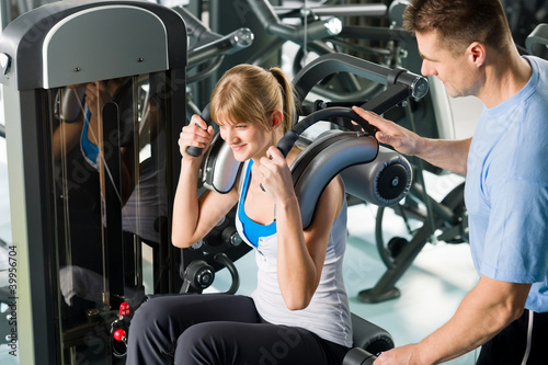 Fitness center young woman exercise with trainer