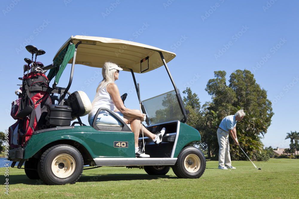 Happy Senior Couple Playing Golf With Cart