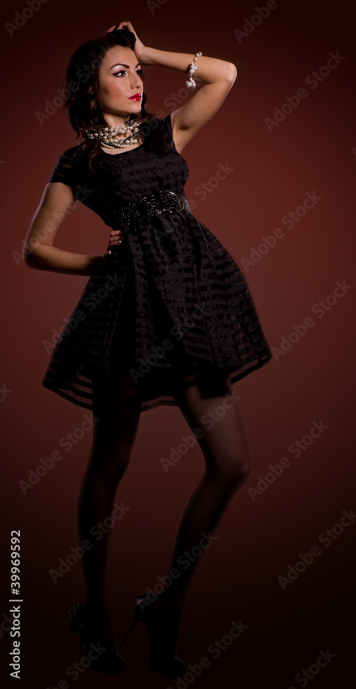 Beautiful young woman in dress on dark background. Beautiful young woman in dress on dark background.