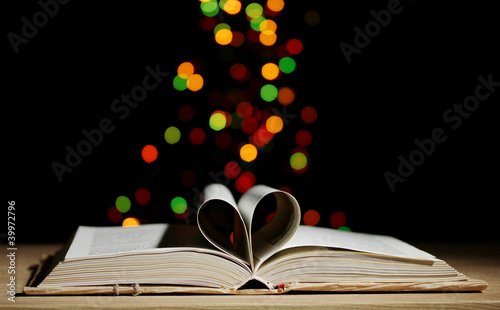 open book on wooden table on bright background