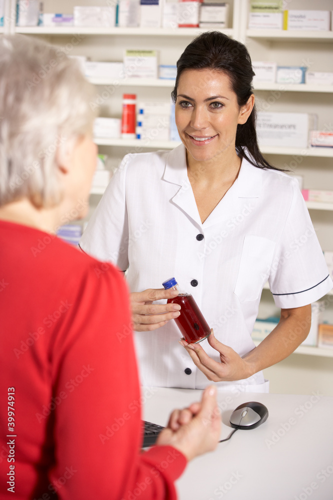 Fototapeta premium American pharmacist dispensing to senior woman