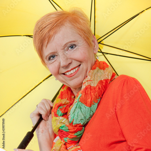 Gut gelaunte Seniorin mit Regenschirm