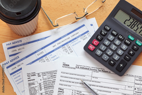1040 tax form with payslips and calculator