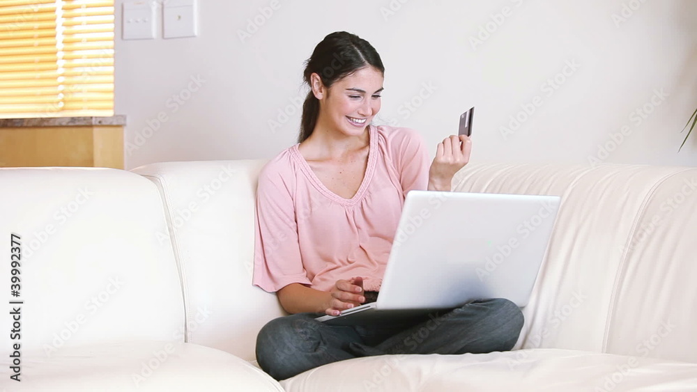 Lady sitting on the couch while using her credit card Lady sitting on the couch while using her credit card