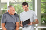 Fitnesstrainer redet mit Senioren