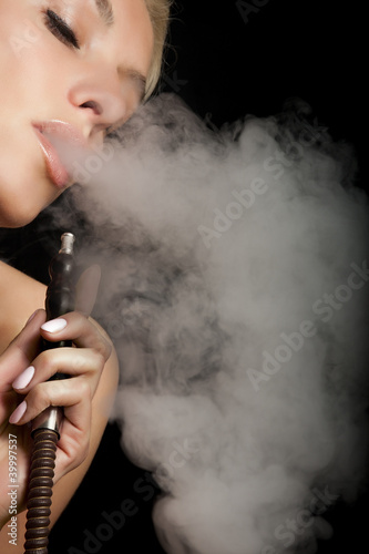 Woman smokes a hookah