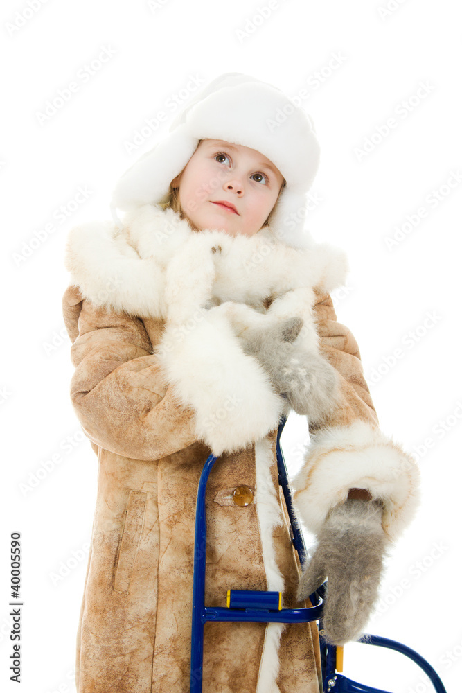 The girl in warm clothes with a sledge surprise looking up The girl in warm clothes with a sledge surprise looking up