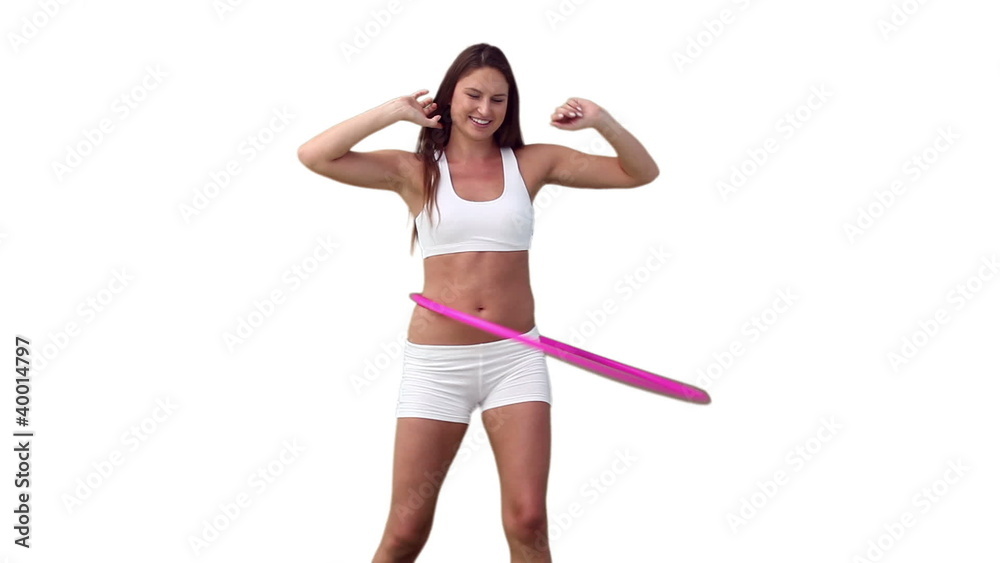 Woman playing with a hula hoop as she spreads her arms Woman playing with a hula hoop as she spreads her arms