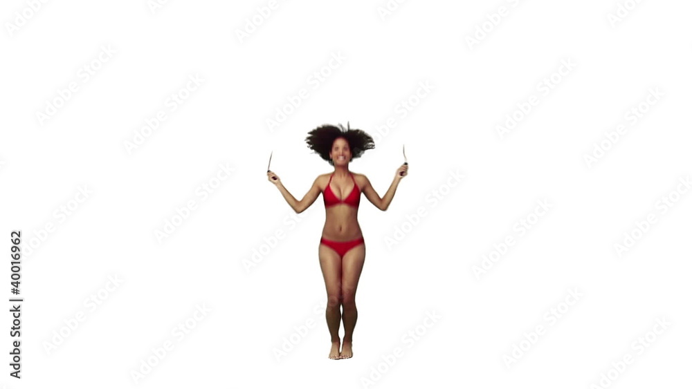 A woman in a bikini is using a skipping rope A woman in a bikini is using a skipping rope