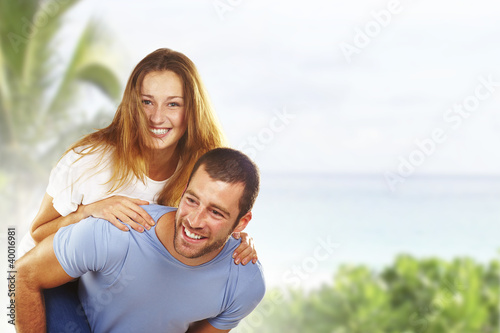 Portrait of a happy young couple having fun together in beach