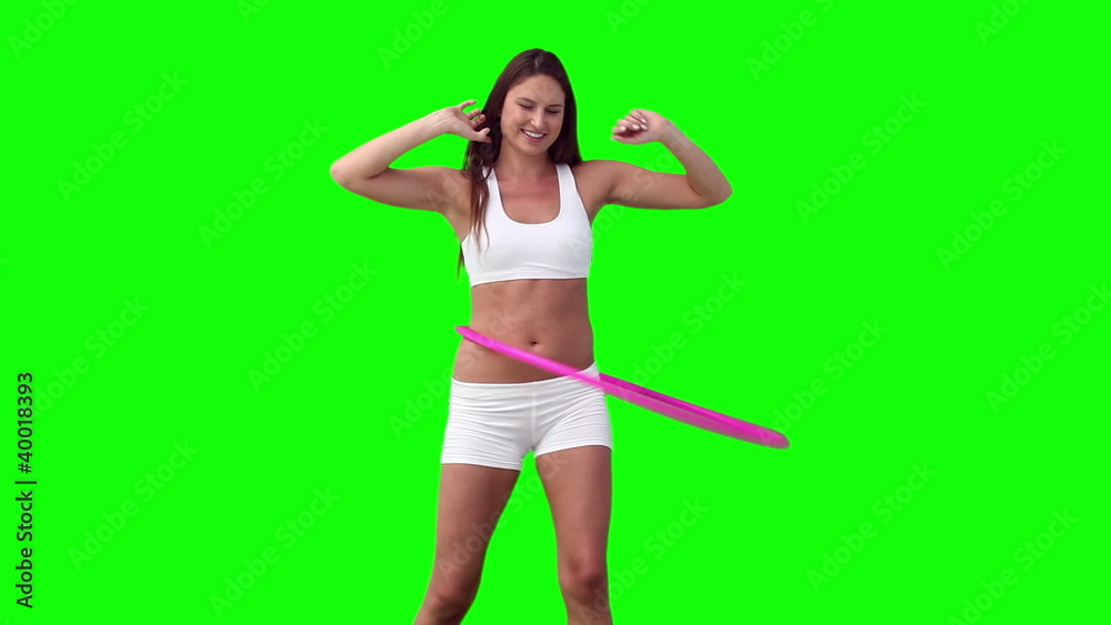 Woman spinning a hula hoop with her arms spread Woman spinning a hula hoop with her arms spread