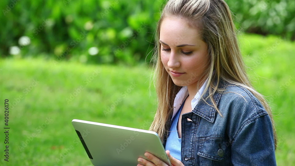 Happy blonde woman using a tablet computer