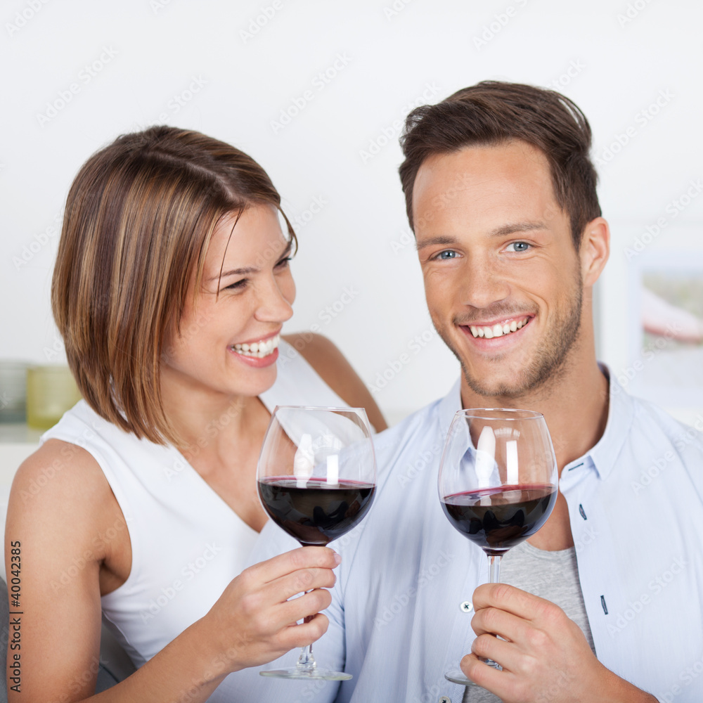 lachendes paar stößt mit rotwein an lachendes paar stößt mit rotwein an
