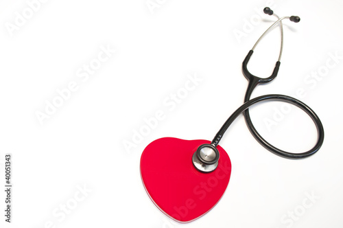 Black medical stethoscope and heart isolated on white
