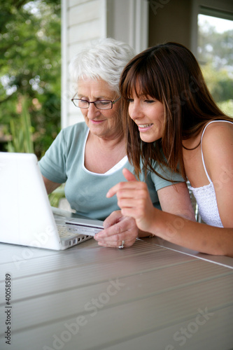 Mother and daughter using laptop photo