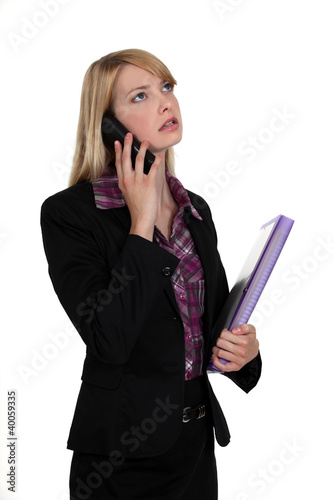 Woman with folder making telephone call photo