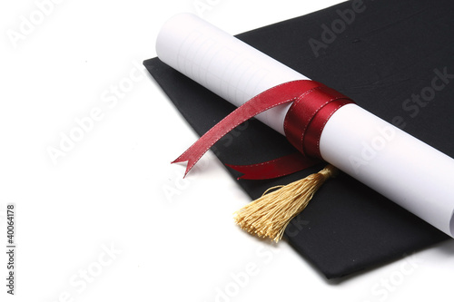 A university diploma with a red ribbon isolated on white photo