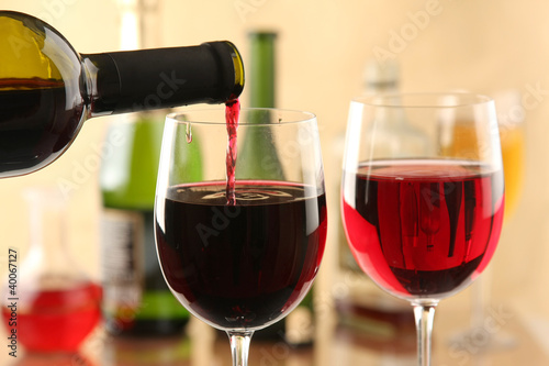 Pouring red wine into glasses