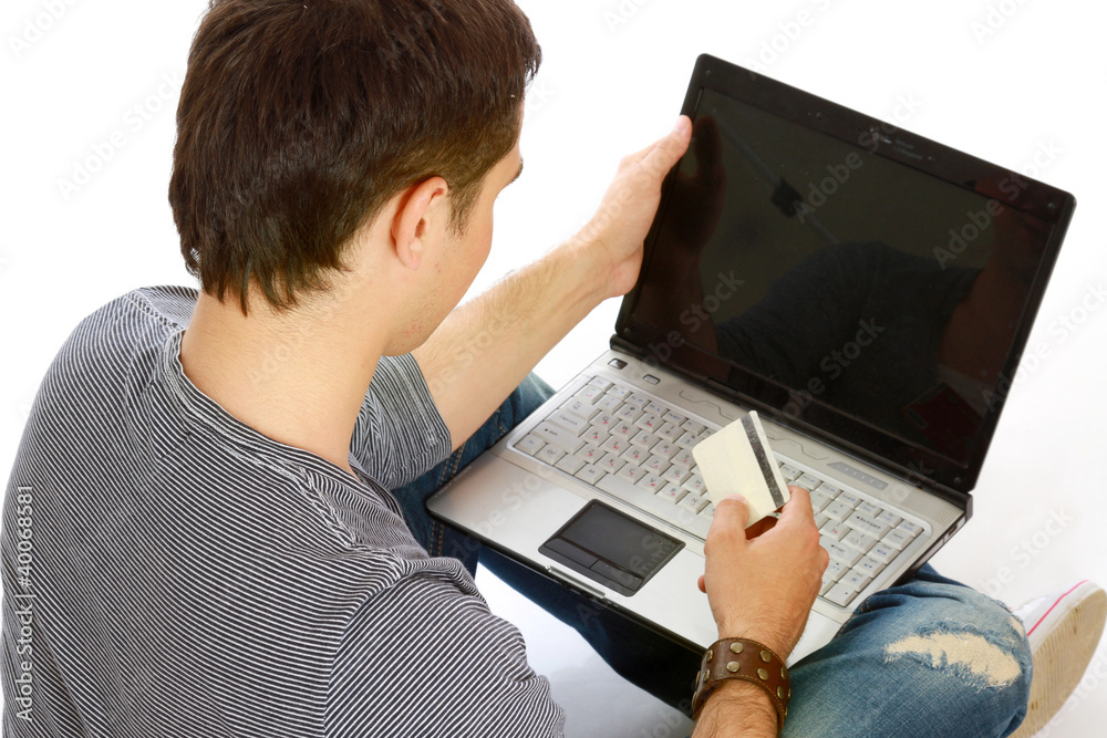 A young guy sitting on the floor with a laptop A young guy sitting on the floor with a laptop