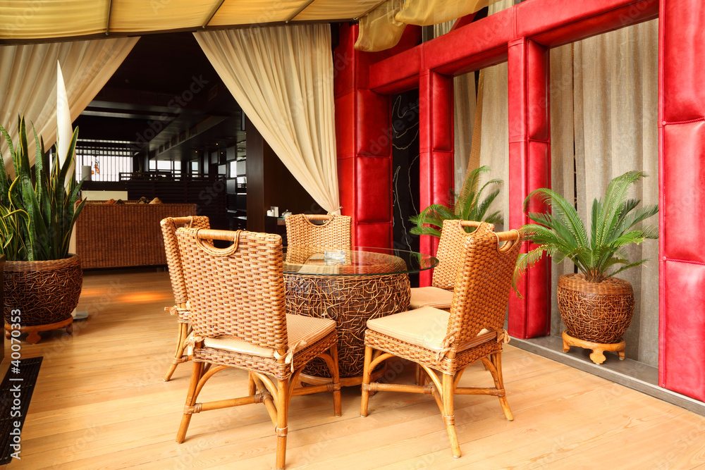 Fototapeta premium Beautiful wicker chairs and table in empty classy restaurant