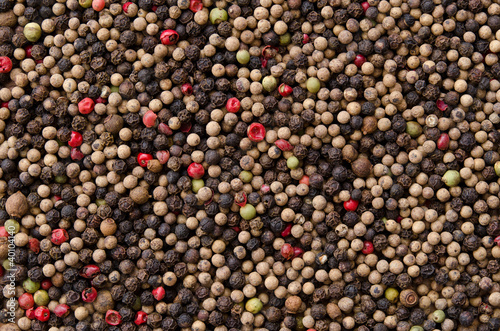 Pile of mixed peppercorns forming an even surface.