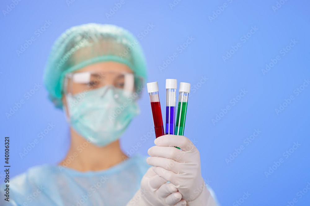 Medical test tube samples in doctor's hand on blue background Medical test tube samples in doctor's hand on blue background