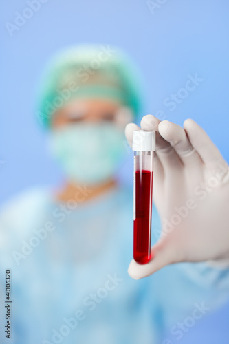 Medical test tube samples in doctor's hand on blue background