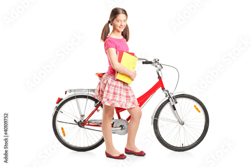 Full length portrait a girl holding a notebooks and a bike