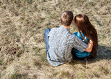 Romantic young couple sitting together in park