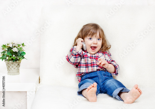beautiful little child holds a cell phone